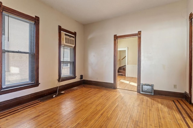 unfurnished room with light wood-type flooring, visible vents, and baseboards