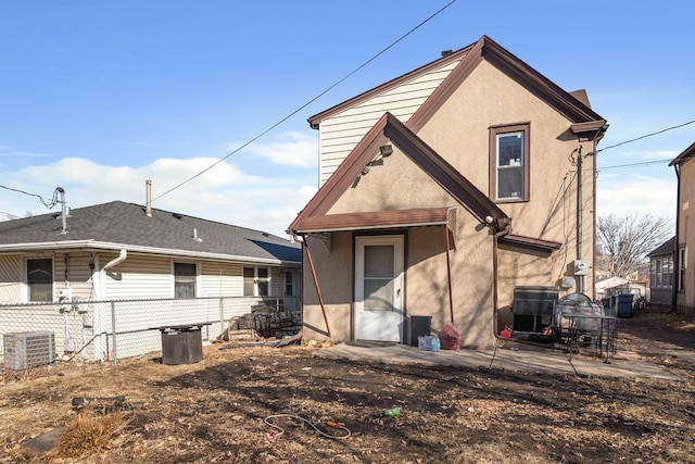 rear view of house with a patio, fence, cooling unit, and stucco siding