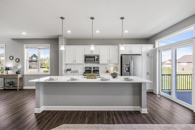 3485 109th Ln NE, Blaine, MN 55449 - kitchen with stainless steel appliances, dark wood-type flooring, baseboards, a large island with sink, and recessed lighting
