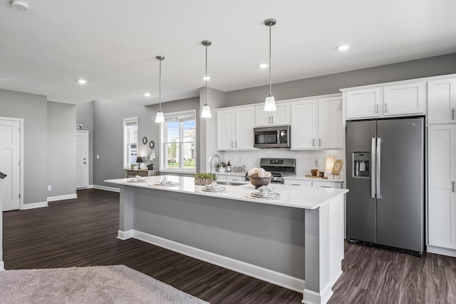 3485 109th Ln NE, Blaine, MN 55449 - kitchen featuring appliances with stainless steel finishes, a sink, dark wood-type flooring, light countertops, and a center island with sink