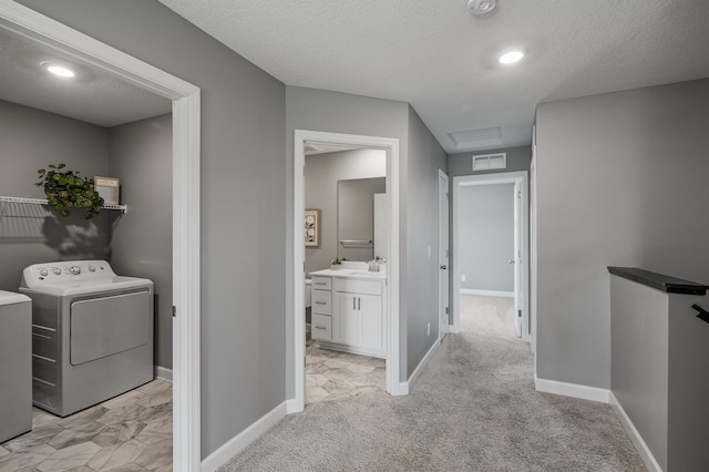 3485 109th Ln NE, Blaine, MN 55449 - corridor with washer / dryer, a sink, baseboards, a textured ceiling, and light carpet