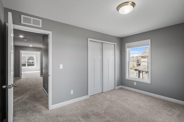 3485 109th Ln NE, Blaine, MN 55449 - unfurnished bedroom with carpet floors, a textured ceiling, multiple windows, and baseboards