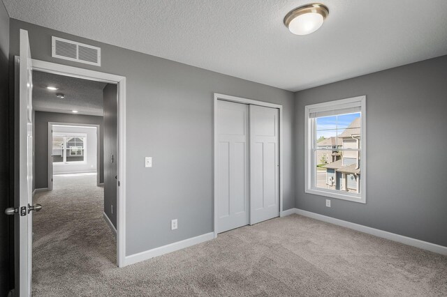 3485 109th Ln NE, Blaine, MN 55449 - unfurnished bedroom featuring carpet, multiple windows, a textured ceiling, and baseboards