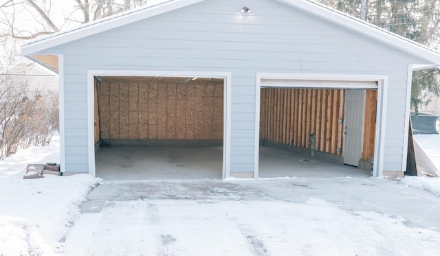 snow covered garage featuring a garage