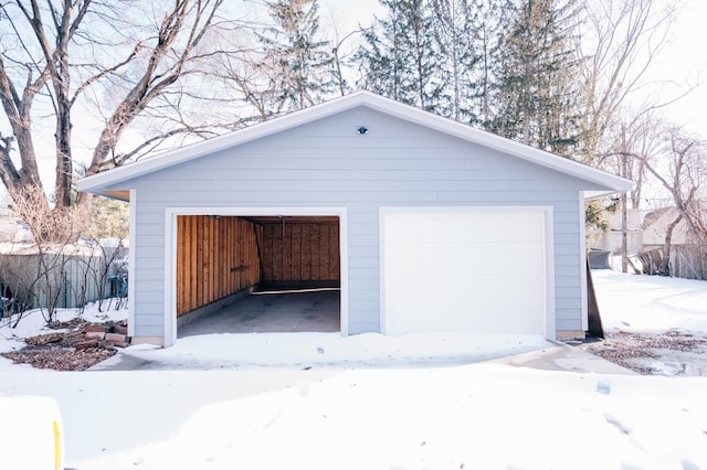 snow covered garage featuring a detached garage