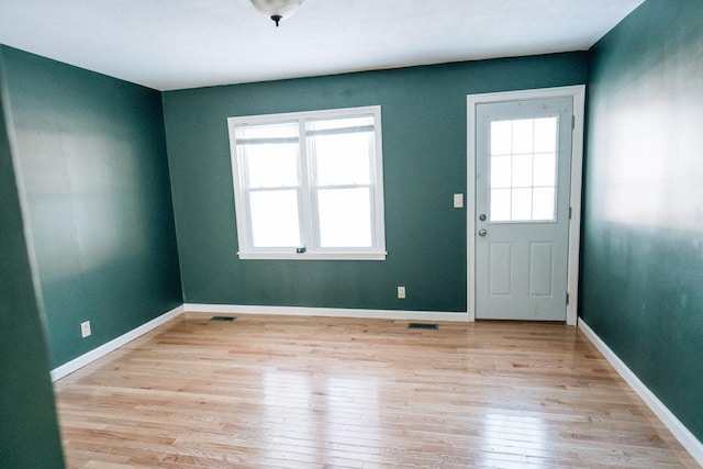 interior space featuring visible vents, light wood-type flooring, and baseboards