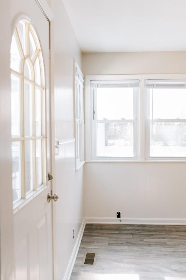 interior space featuring plenty of natural light, baseboards, visible vents, and light wood-type flooring