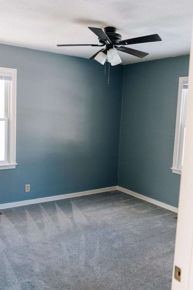 spare room featuring a textured ceiling, baseboards, carpet, and ceiling fan