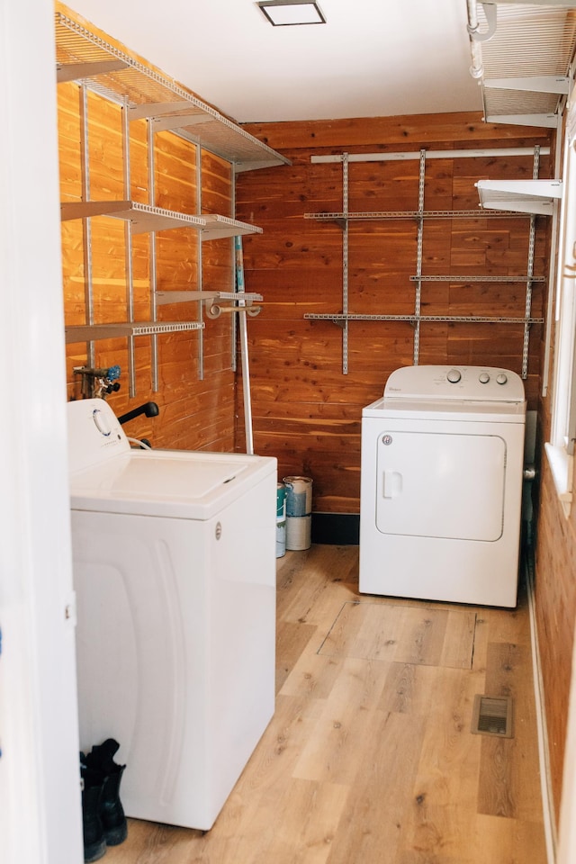 washroom featuring laundry area, washing machine and dryer, and wood finished floors