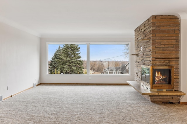 unfurnished living room with carpet, visible vents, a fireplace, and baseboards