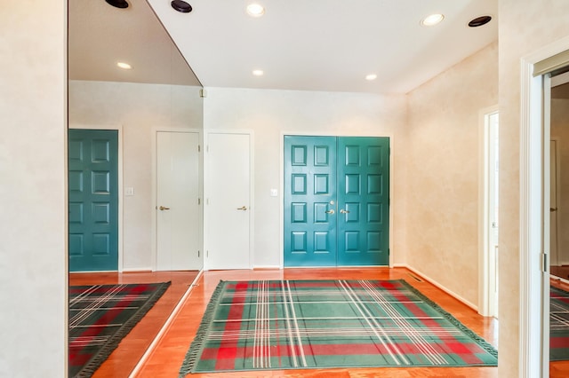 foyer featuring baseboards, wood finished floors, and recessed lighting