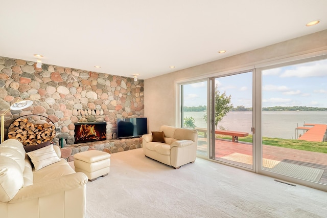 carpeted living area featuring a fireplace, visible vents, and recessed lighting