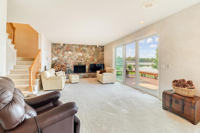 carpeted living area with stairway, a fireplace, visible vents, and recessed lighting