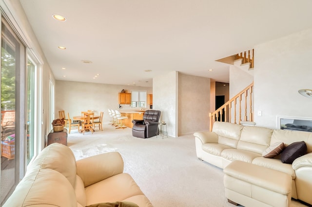 living room featuring light carpet, stairs, and recessed lighting