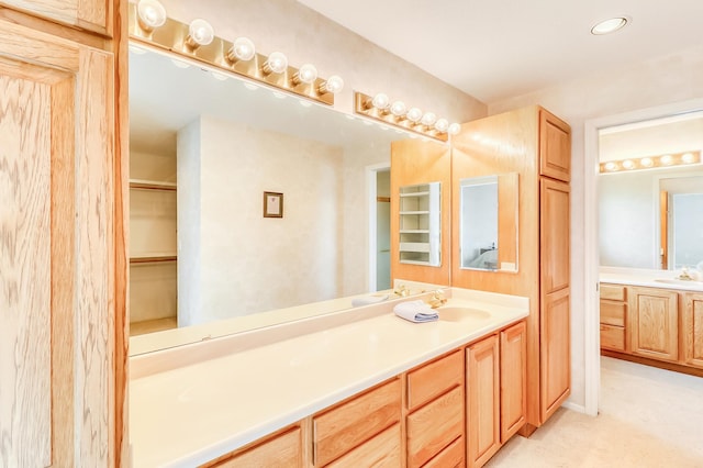 full bathroom featuring recessed lighting, vanity, and a spacious closet