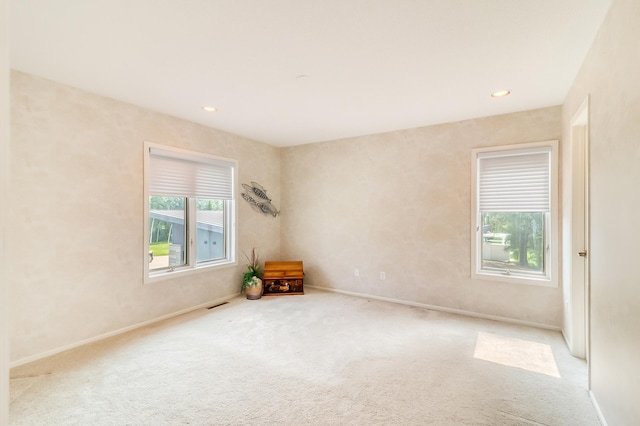 carpeted spare room featuring visible vents, baseboards, and recessed lighting