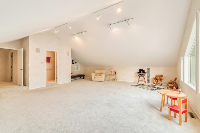 additional living space featuring light colored carpet, visible vents, and vaulted ceiling