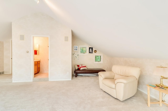 sitting room featuring lofted ceiling, light carpet, and baseboards