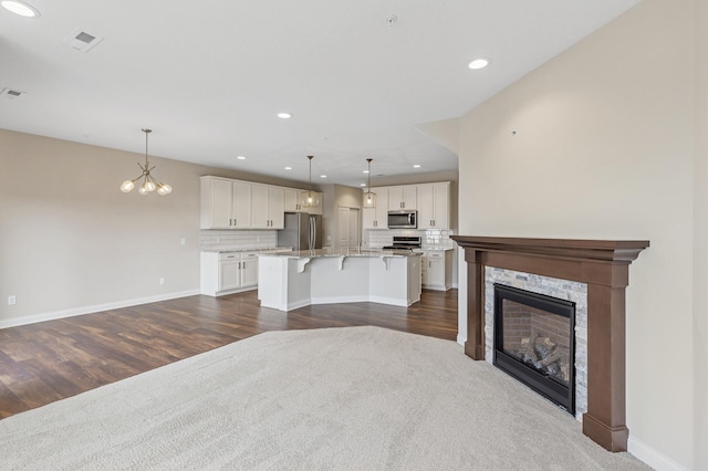 living room with a stone fireplace, recessed lighting, visible vents, baseboards, and dark wood-style floors