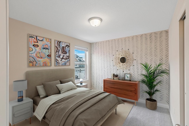 bedroom featuring an accent wall, carpet flooring, wallpapered walls, and baseboards