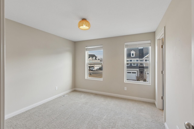 empty room with light carpet and baseboards