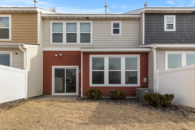 rear view of house featuring fence and central AC unit