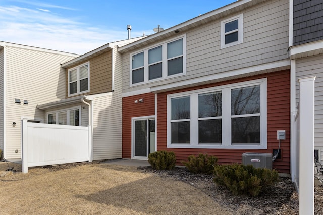 view of front of property with central AC unit and fence