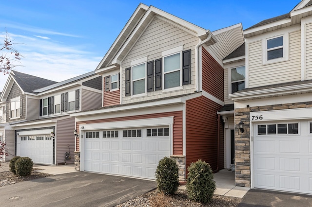 view of front of property with a garage, stone siding, and driveway