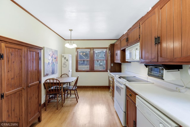 kitchen featuring white appliances, light countertops, ornamental molding, brown cabinets, and light wood finished floors