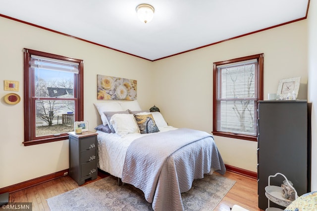 bedroom featuring ornamental molding, wood finished floors, and baseboards