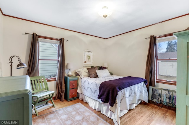 bedroom with crown molding and wood finished floors