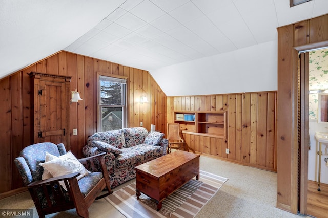 living room featuring vaulted ceiling, wood walls, and plenty of natural light