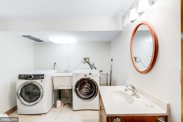 laundry room with laundry area, light tile patterned flooring, a sink, and washer and clothes dryer