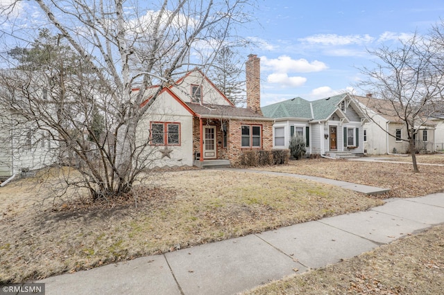 view of front of property with a chimney and brick siding