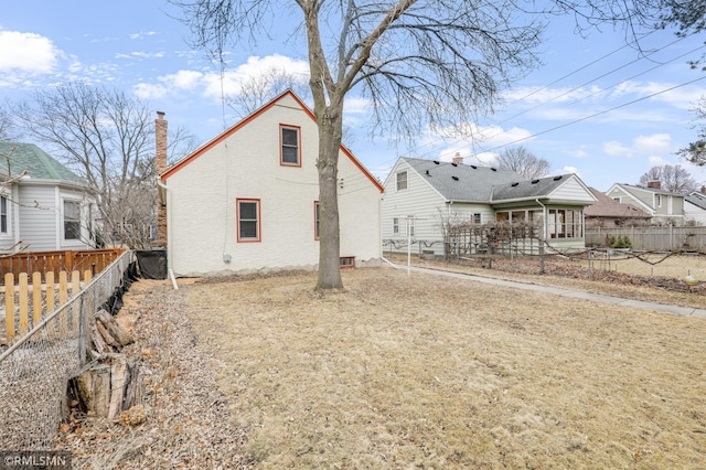 back of property featuring a fenced backyard and a chimney