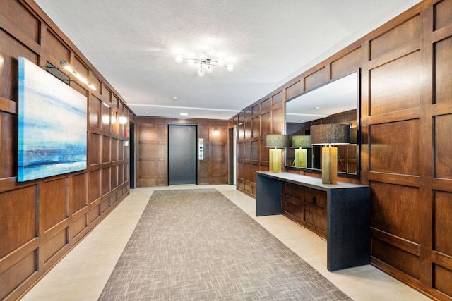 interior space featuring elevator, wooden walls, and a decorative wall