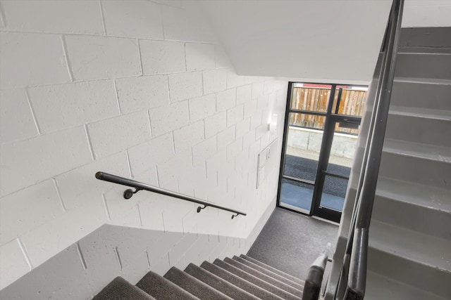 stairs featuring concrete block wall