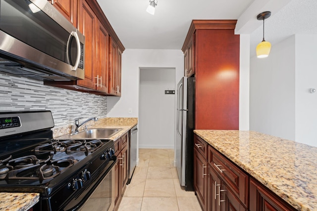 kitchen with light tile patterned floors, a sink, appliances with stainless steel finishes, decorative backsplash, and pendant lighting