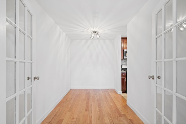 hallway with light wood-style floors and baseboards