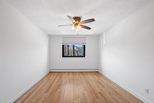 empty room with light wood finished floors, a baseboard radiator, and baseboards