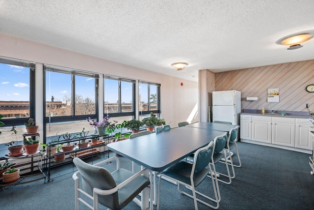 dining room featuring dark carpet and a textured ceiling