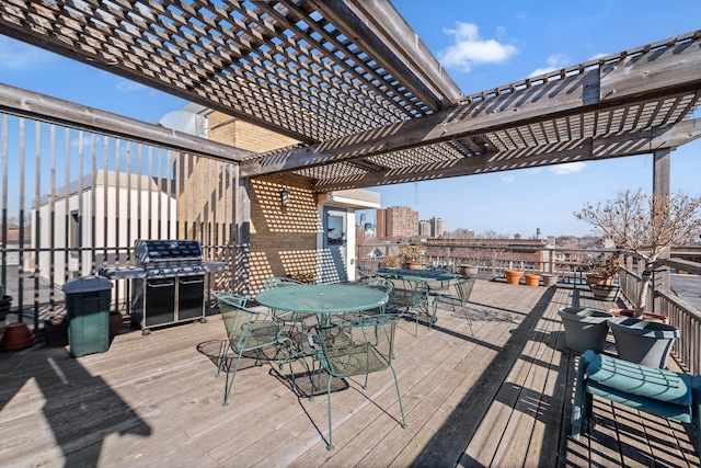 deck with outdoor dining space, area for grilling, and a pergola