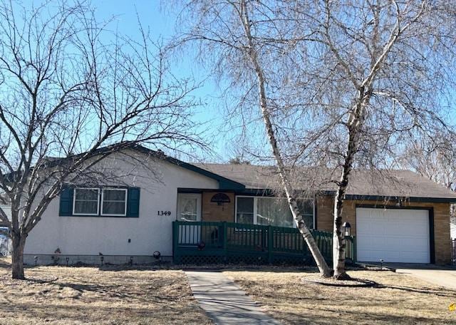 ranch-style house featuring covered porch, an attached garage, and concrete driveway