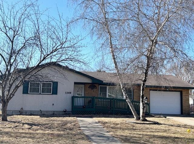 ranch-style home featuring a garage, covered porch, and driveway