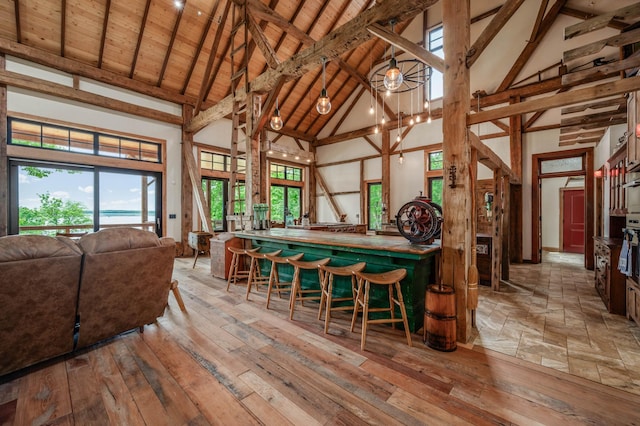 interior space with high vaulted ceiling, hardwood / wood-style floors, beamed ceiling, and wooden ceiling