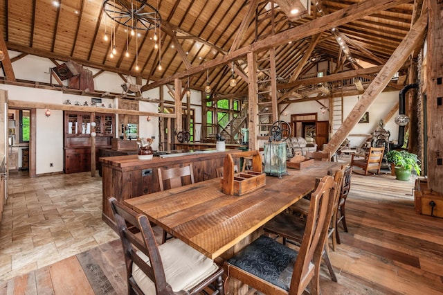 dining room with stairs, high vaulted ceiling, and wood finished floors