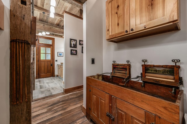 kitchen featuring beamed ceiling, wood finished floors, wood ceiling, and baseboards