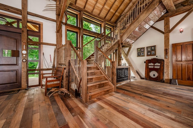 staircase with high vaulted ceiling, wood-type flooring, wood ceiling, and a healthy amount of sunlight