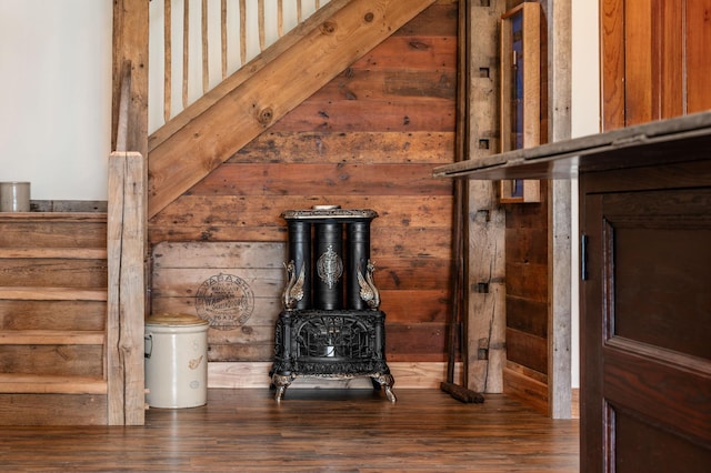 details with a wood stove, wood walls, and wood finished floors