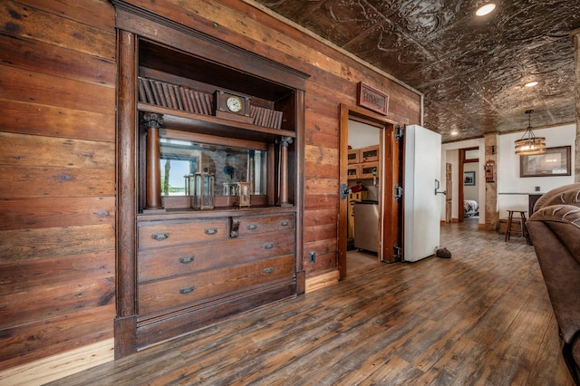 kitchen with dark wood-style floors, wood walls, and an ornate ceiling